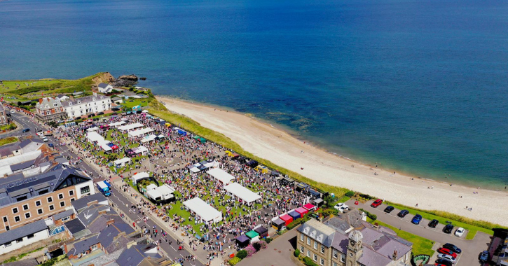 Aerial image of Seaham Food Festival showing crowds, stalls and the North Sea.